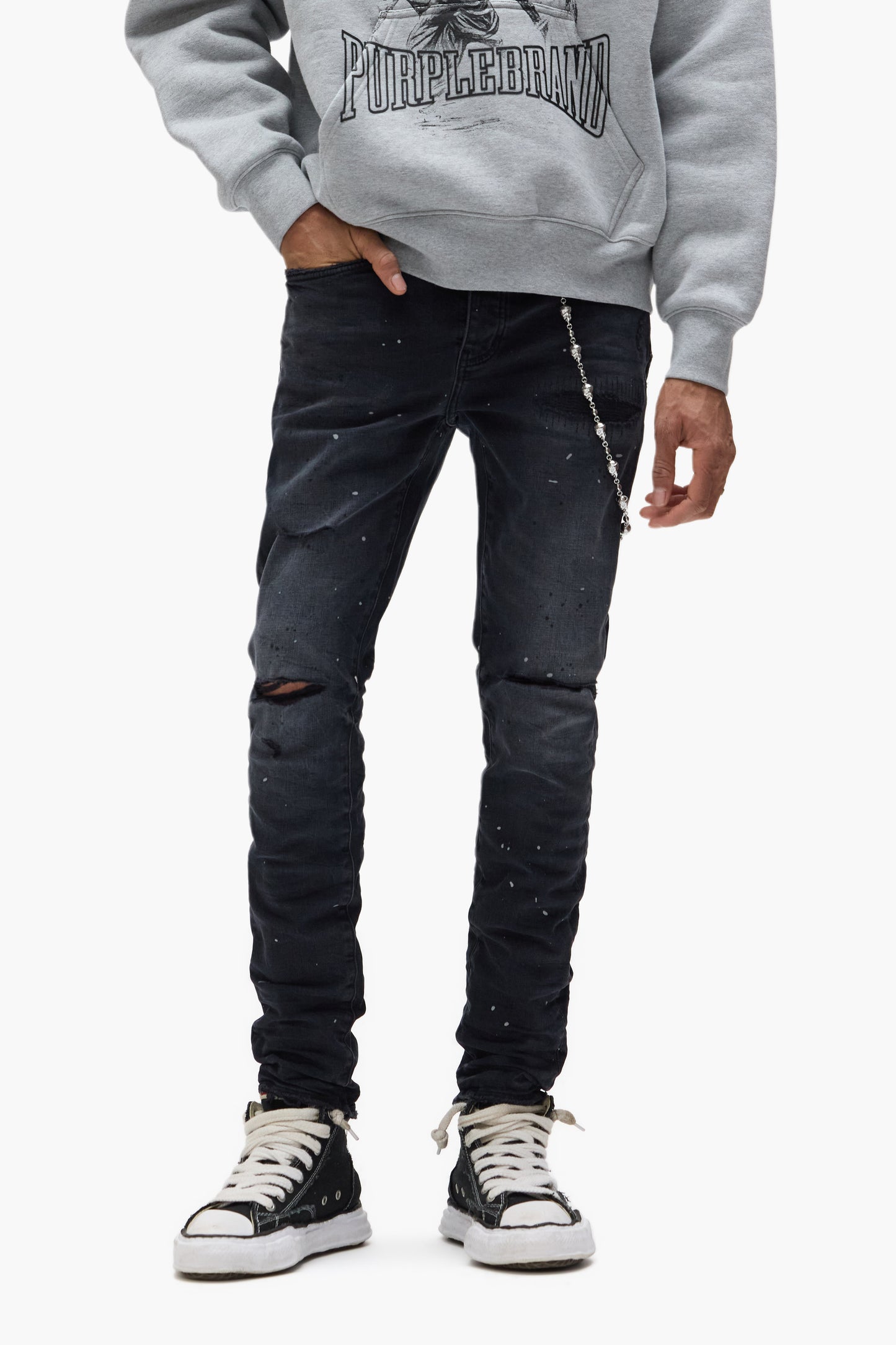 Black wash low rise skinny jeans with reflective paint and knee tears in premium stretch denim.