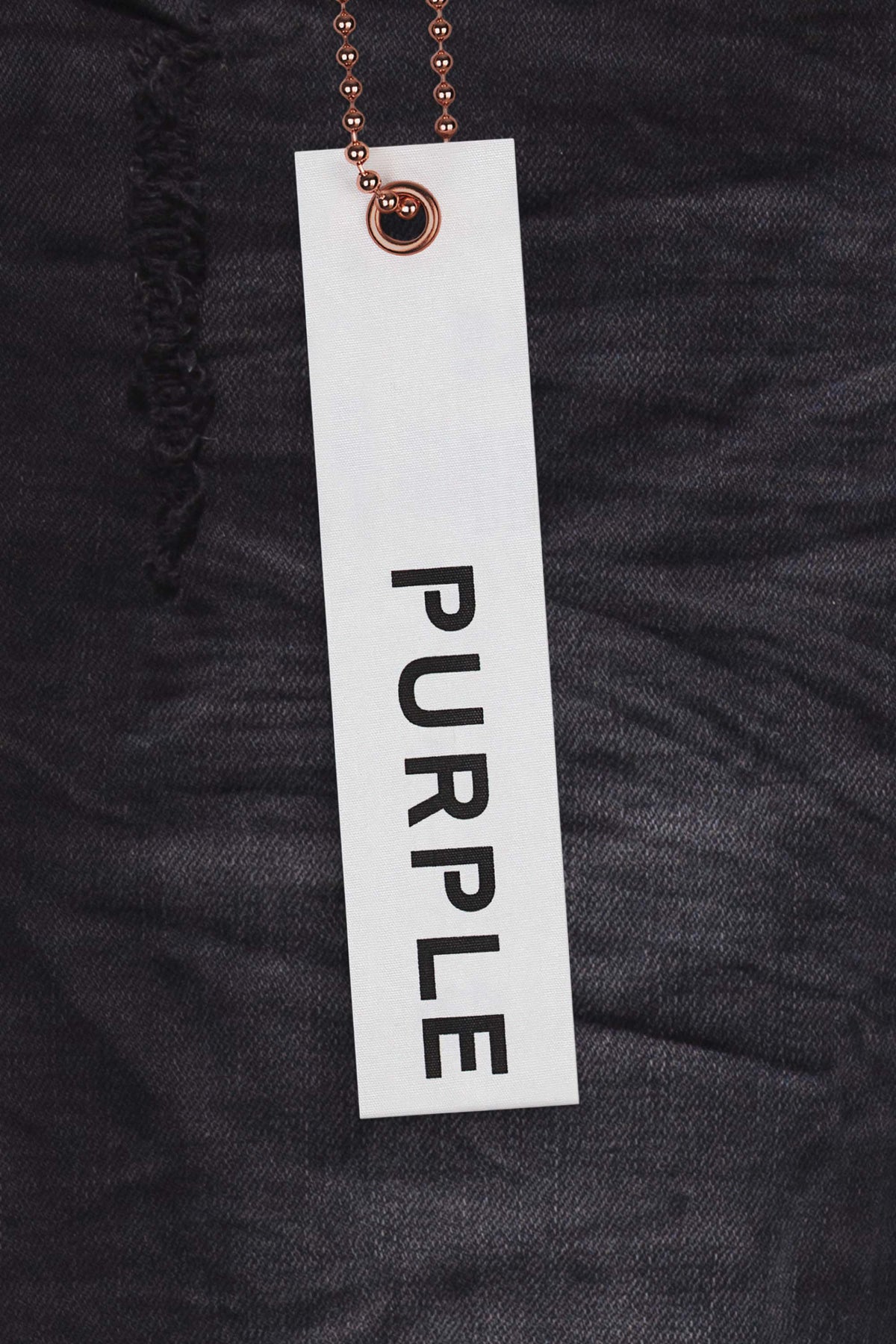 P002 mid-rise slim jean in black wash with blowout detailing at knees and light fading.