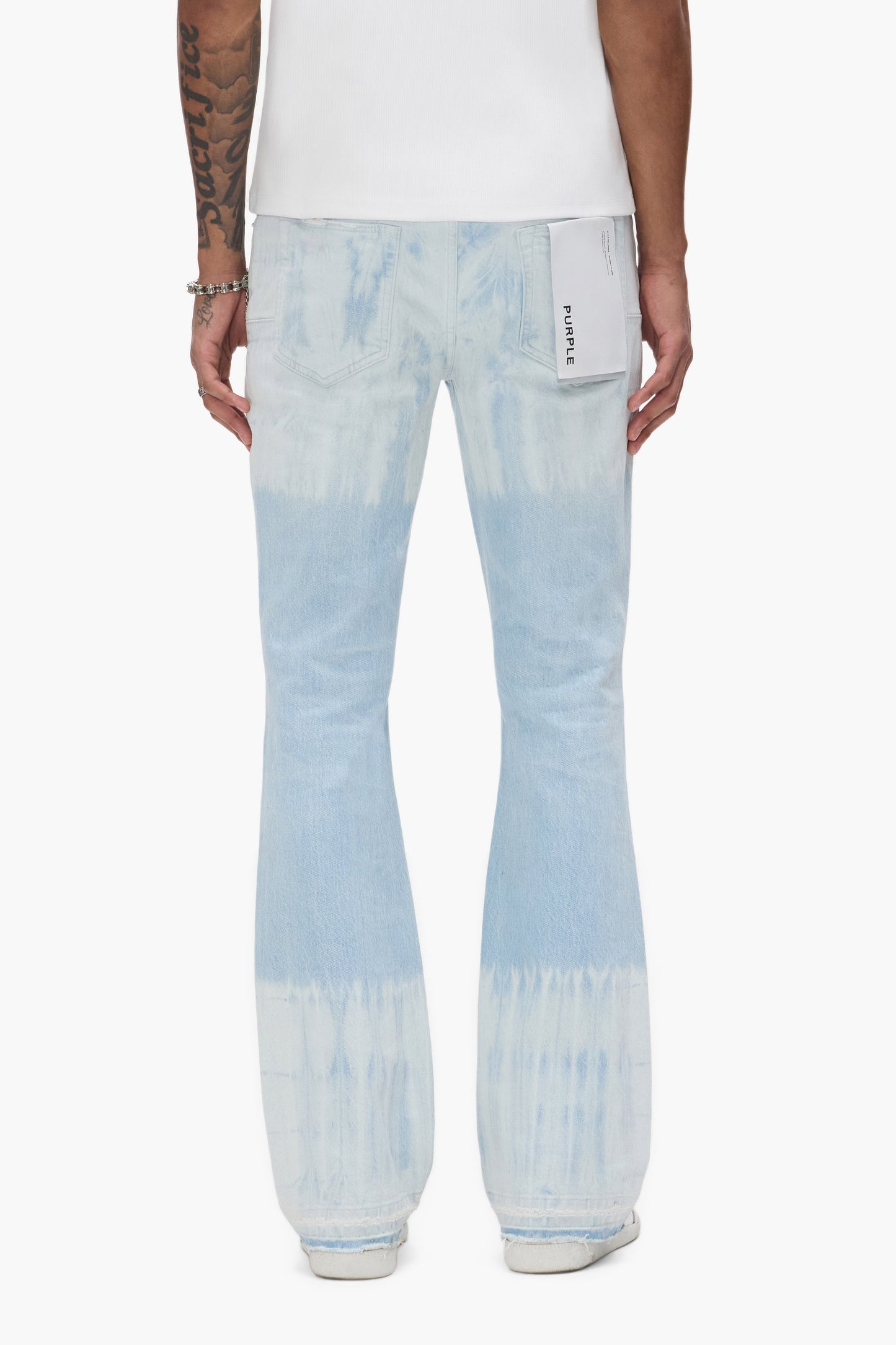 Tie Dye Flare Denim in various sizes with low rise and slim fit, featuring right front rip and repair.