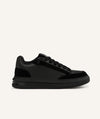 Black running shoe with pink sole on a white background