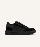 Black running shoe with pink sole on a white background
